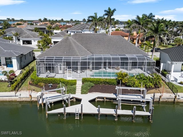 back of house featuring boat lift, an outdoor pool, a residential view, and a water view