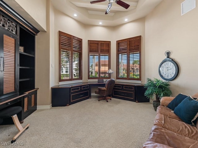 carpeted home office with visible vents, ceiling fan, built in desk, recessed lighting, and a towering ceiling