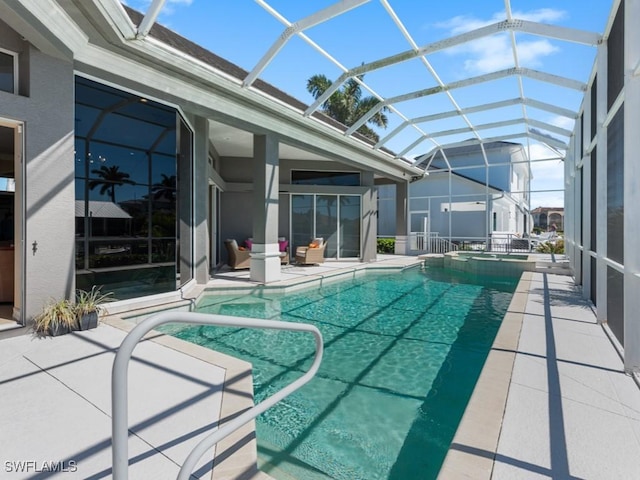 view of swimming pool with a lanai, a pool with connected hot tub, and a patio