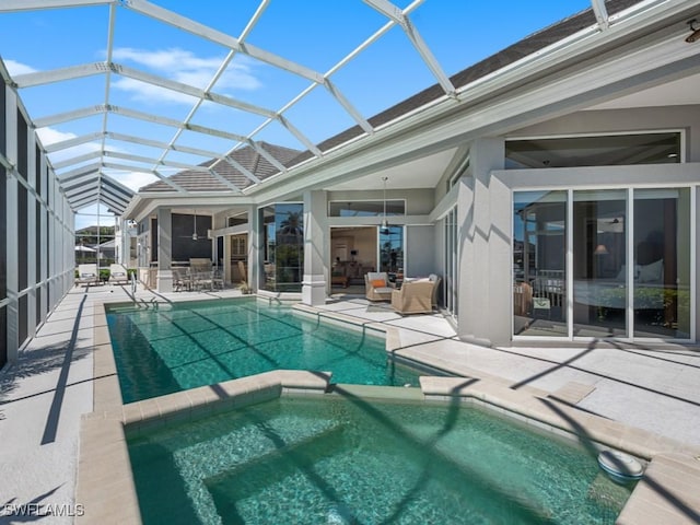 view of pool with glass enclosure, a patio, and a pool with connected hot tub