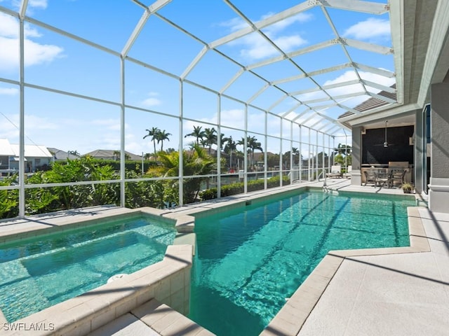 view of pool with glass enclosure, a pool with connected hot tub, and a patio