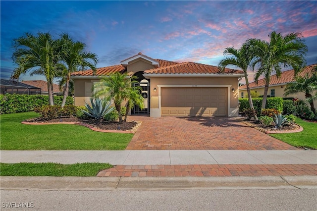 mediterranean / spanish home featuring a tile roof, decorative driveway, an attached garage, and stucco siding