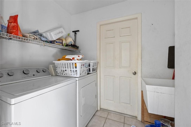 clothes washing area featuring washer and clothes dryer, laundry area, and light tile patterned floors