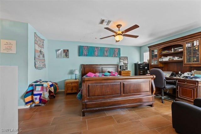 bedroom featuring baseboards, visible vents, built in desk, and ceiling fan