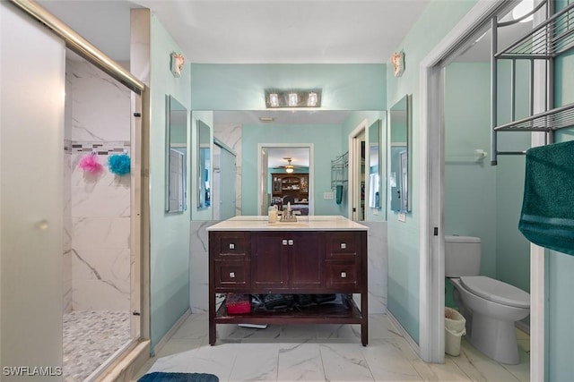 bathroom featuring a marble finish shower, marble finish floor, toilet, and vanity