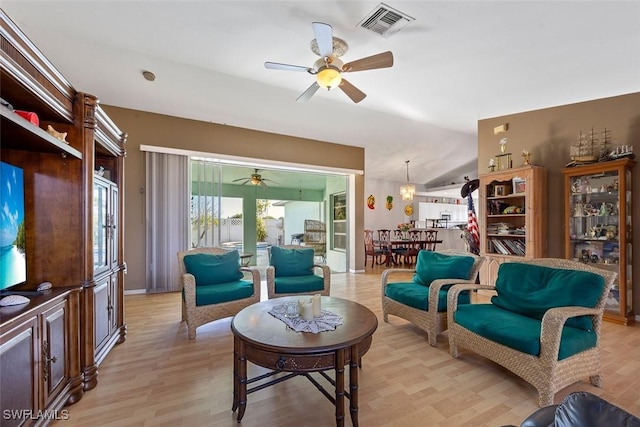 living room with visible vents, light wood-style floors, a ceiling fan, and vaulted ceiling