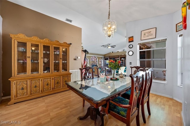 dining room featuring visible vents, baseboards, lofted ceiling, ceiling fan with notable chandelier, and light wood-style floors