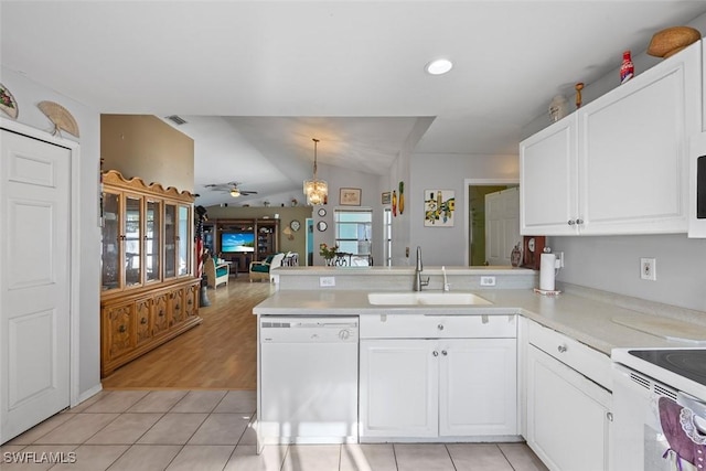 kitchen with white appliances, visible vents, a peninsula, ceiling fan, and a sink