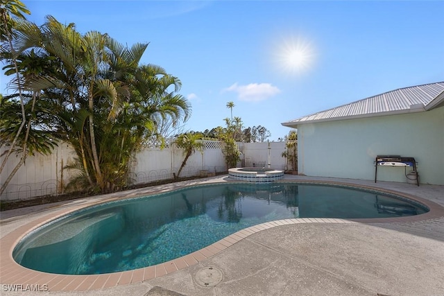 view of swimming pool with a patio, a pool with connected hot tub, and a fenced backyard