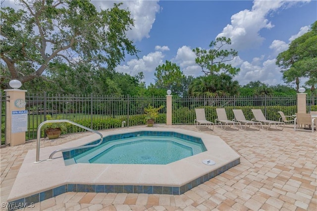 view of pool with a patio, a community hot tub, and fence