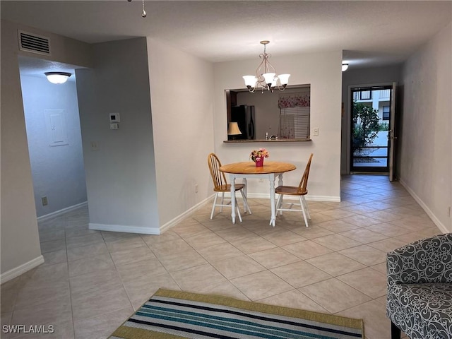 dining room featuring light tile patterned floors, baseboards, visible vents, and a chandelier