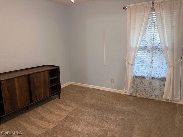 empty room with carpet flooring, a healthy amount of sunlight, and baseboards