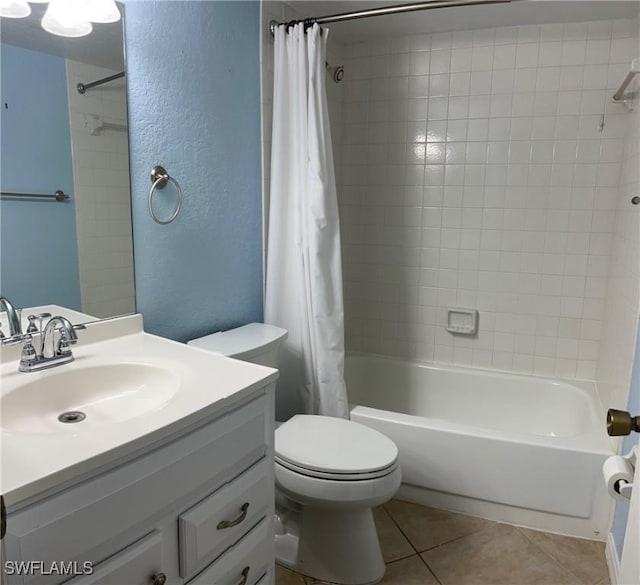 bathroom featuring vanity, shower / bathtub combination with curtain, tile patterned floors, toilet, and a textured wall