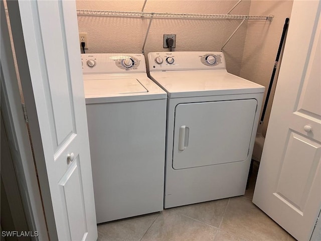 laundry area with light tile patterned floors, laundry area, and separate washer and dryer