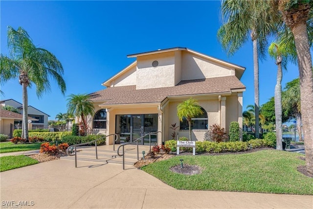 view of front facade with stucco siding and a front lawn