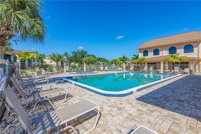 community pool featuring a patio and fence