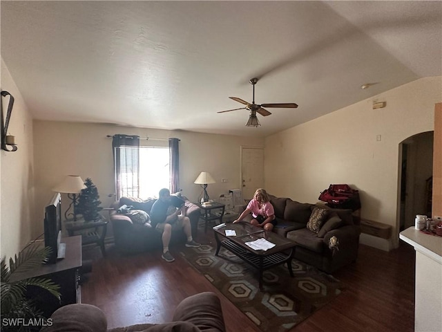 living area with ceiling fan, arched walkways, lofted ceiling, and wood finished floors