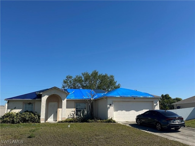 single story home with stucco siding, driveway, fence, a front yard, and a garage