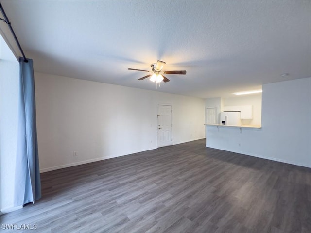 unfurnished living room with baseboards, a textured ceiling, a ceiling fan, and dark wood-style flooring