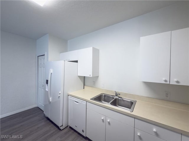 kitchen featuring a sink, light countertops, white cabinets, white appliances, and dark wood-style flooring