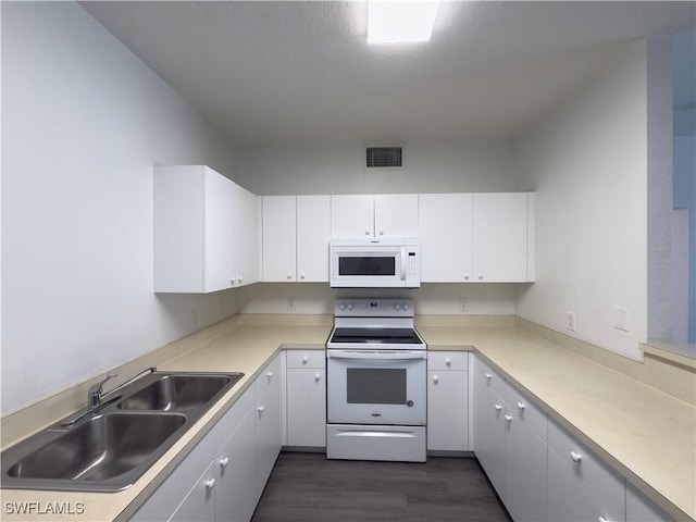 kitchen featuring white appliances, visible vents, a sink, light countertops, and white cabinets