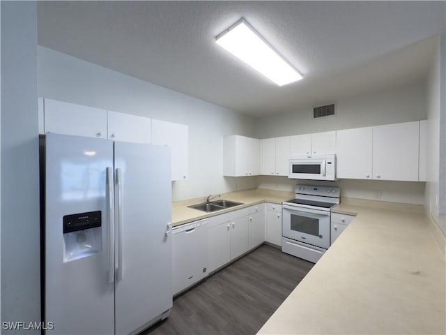 kitchen featuring visible vents, a sink, white cabinetry, white appliances, and light countertops