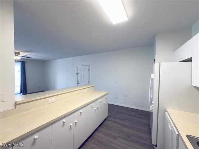 kitchen with light countertops, white cabinets, dark wood-style flooring, and freestanding refrigerator