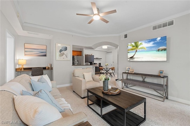 living area featuring visible vents, arched walkways, light colored carpet, and ceiling fan