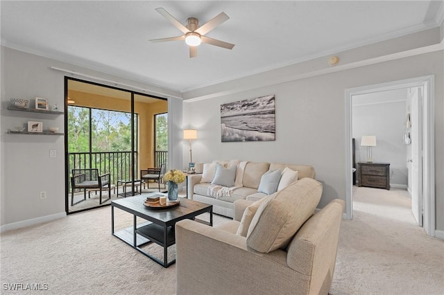 living area featuring a ceiling fan, crown molding, light colored carpet, and baseboards