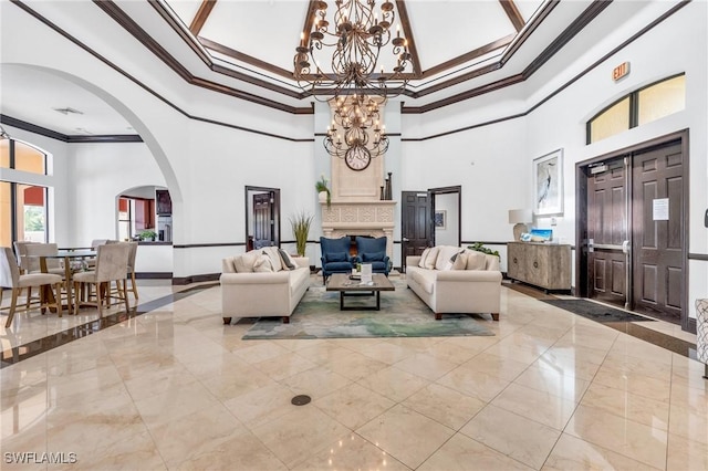 living room featuring an inviting chandelier, a high ceiling, arched walkways, ornamental molding, and marble finish floor