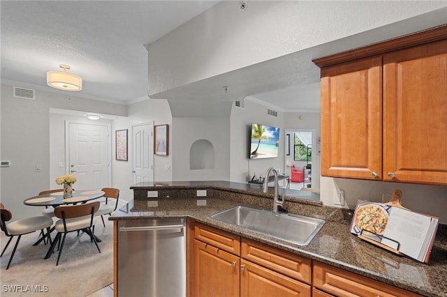 kitchen featuring visible vents, ornamental molding, a sink, stainless steel dishwasher, and dark stone counters