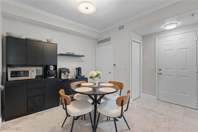 dining space featuring visible vents, ornamental molding, a toaster, light tile patterned floors, and light colored carpet