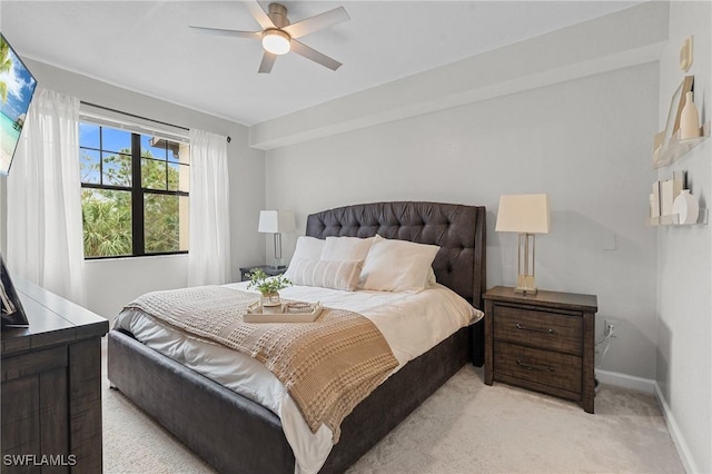 bedroom with a ceiling fan, baseboards, and light carpet