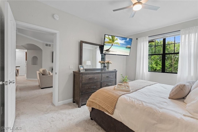 bedroom with visible vents, baseboards, vaulted ceiling, light carpet, and arched walkways