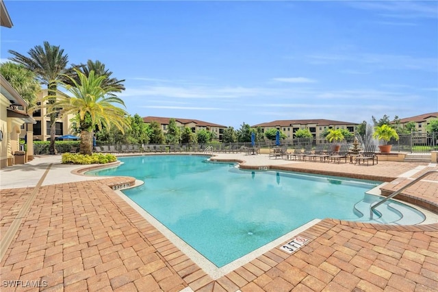 community pool featuring a patio and fence