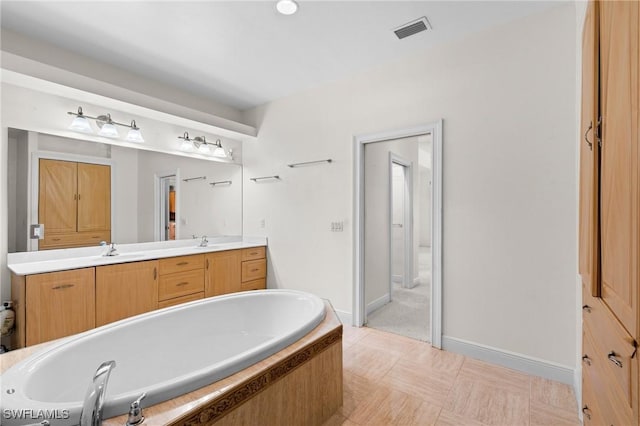 full bathroom featuring a sink, double vanity, visible vents, and a washtub