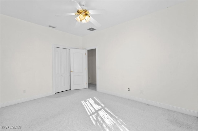 unfurnished room with a ceiling fan, baseboards, visible vents, and light colored carpet