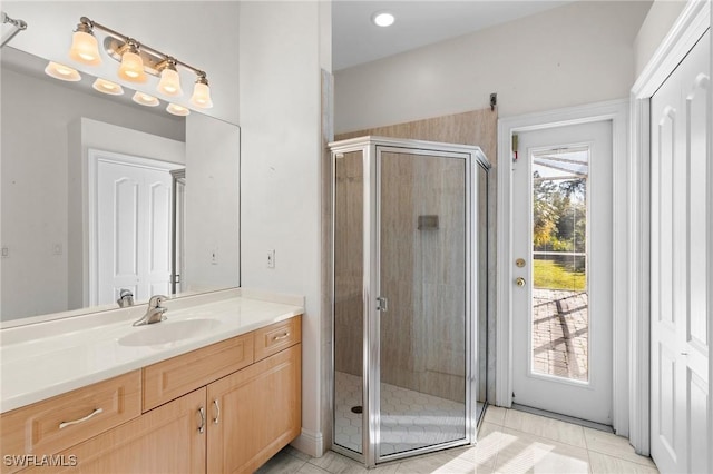 bathroom featuring tile patterned floors, a shower stall, and vanity