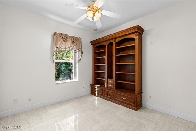 spare room featuring baseboards and ceiling fan