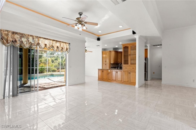 unfurnished living room featuring baseboards, a ceiling fan, a tray ceiling, and ornamental molding