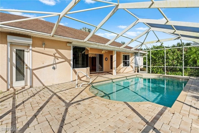 pool featuring glass enclosure and a patio