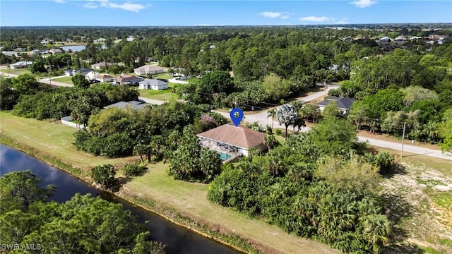 drone / aerial view with a water view and a view of trees