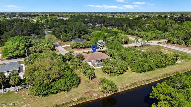 drone / aerial view with a view of trees and a water view