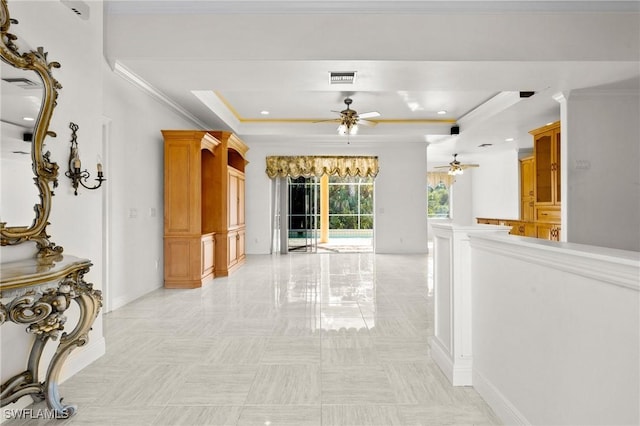 hall featuring a tray ceiling, crown molding, and visible vents