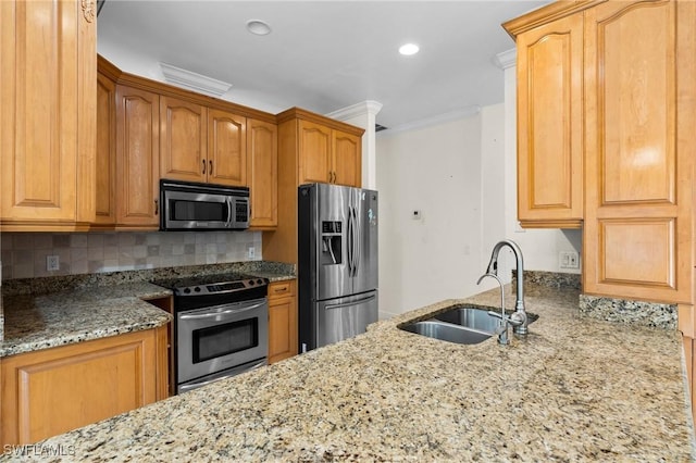 kitchen with tasteful backsplash, ornamental molding, light stone counters, appliances with stainless steel finishes, and a sink