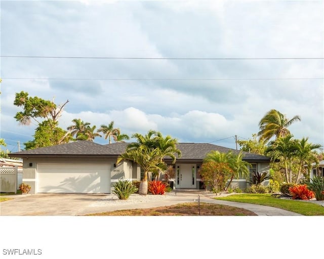 ranch-style house with stucco siding, driveway, an attached garage, and fence