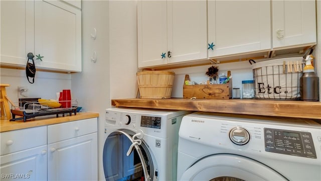 clothes washing area with washer and clothes dryer and cabinet space