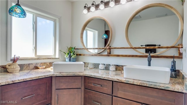 bathroom featuring a sink, visible vents, and double vanity