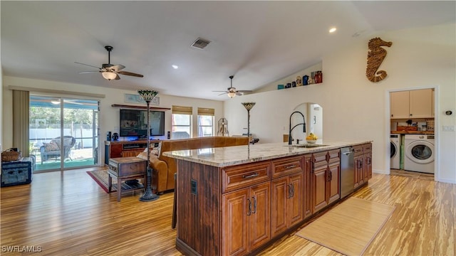 kitchen featuring visible vents, a sink, stainless steel dishwasher, a ceiling fan, and separate washer and dryer