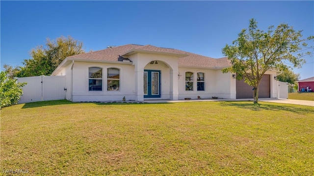 mediterranean / spanish-style house featuring driveway, a gate, fence, a front yard, and a garage